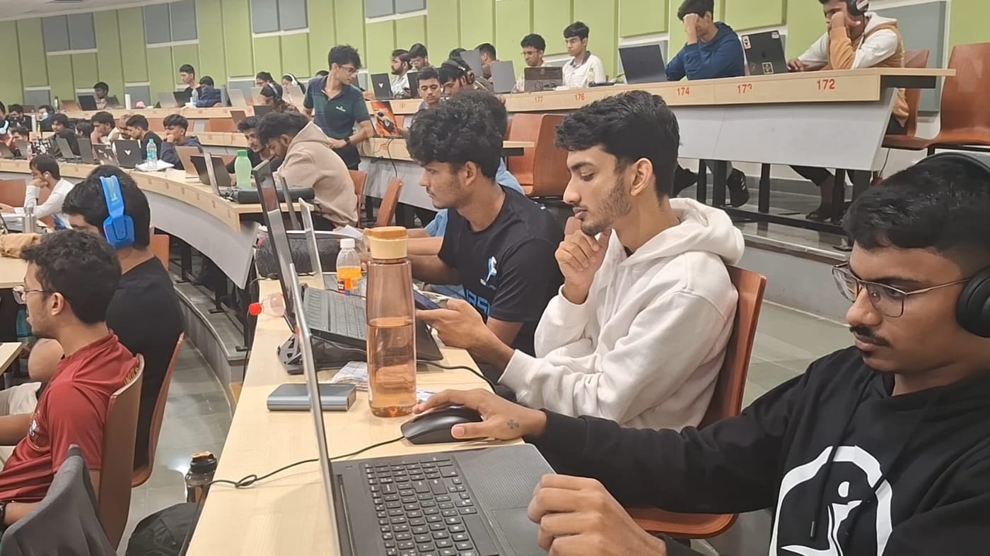 Jared Furtado and teammates working on laptops in a lecture hall full of participants at the Goa Police Hackathon 2025