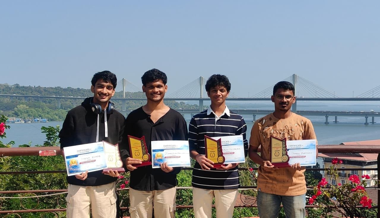 Jared Furtado and his team Qbits holding trophies and certificates of achievement from the Orix Hackathon 2026, on a terrace in Panaji overlooking Atal Setu
